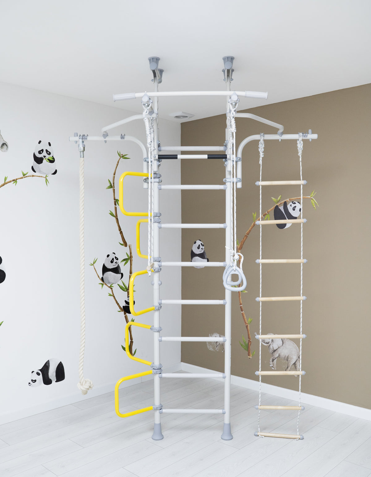 Brainrich steel wall-mounted jungle gym with rope ladder, rings, and climbing rope in a kids room