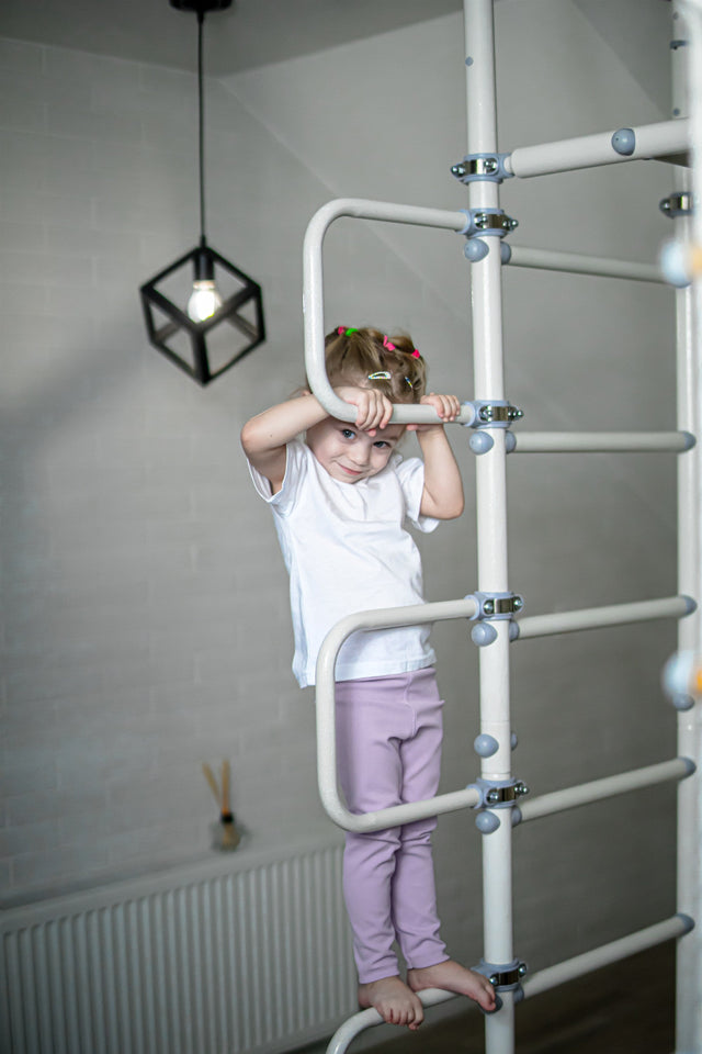 Toddler climbing a compact Brainrich wall ladder in a living room