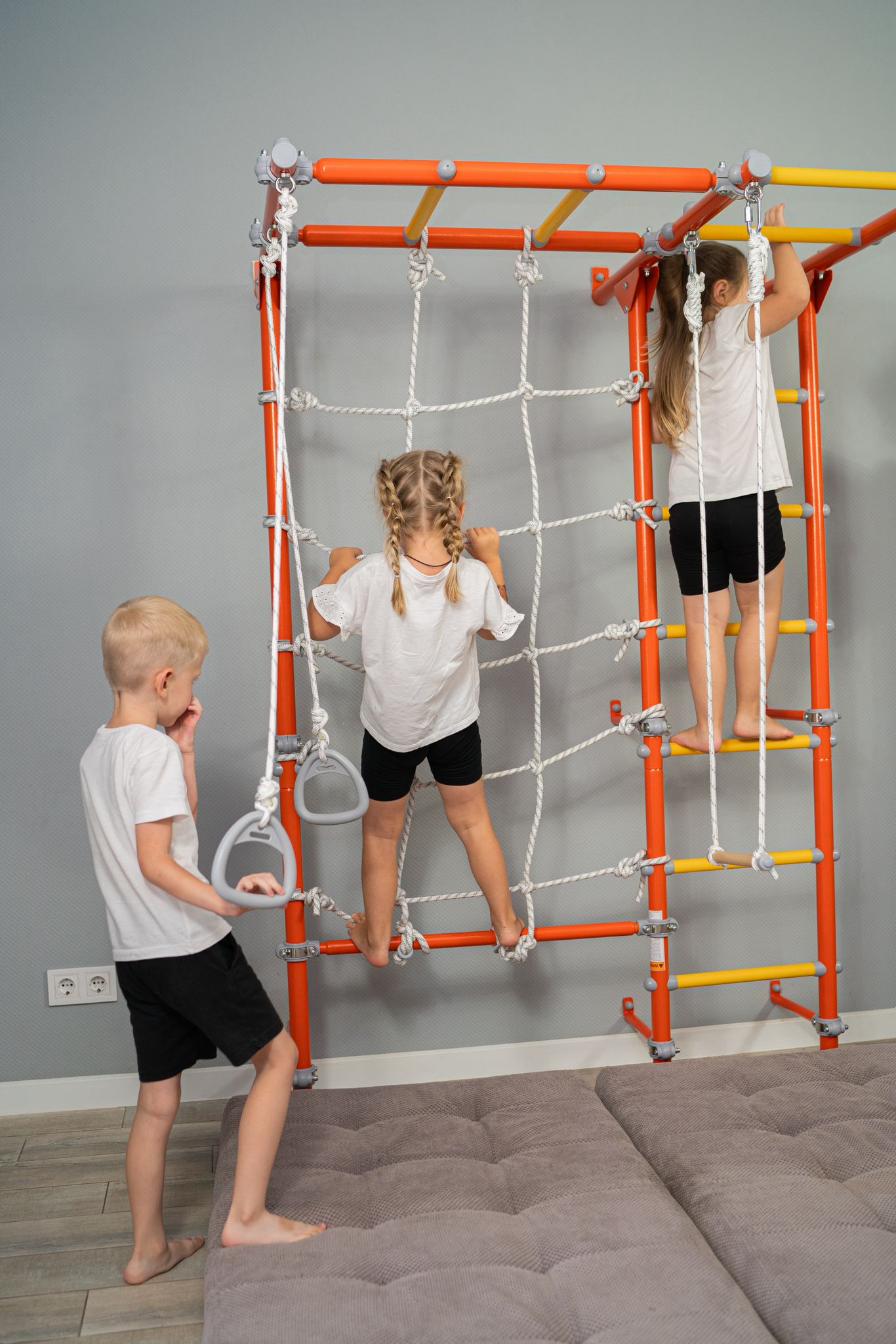 Three kids playing on a wall-mounted Brainrich home play gym, one family with three possible funding lanes: HSA, FSA, or ESA