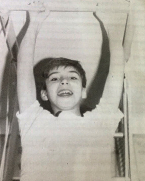 Yegor Nadvornyy as a boy, hanging from the bar of the steel ladder he grew up on in Ukraine