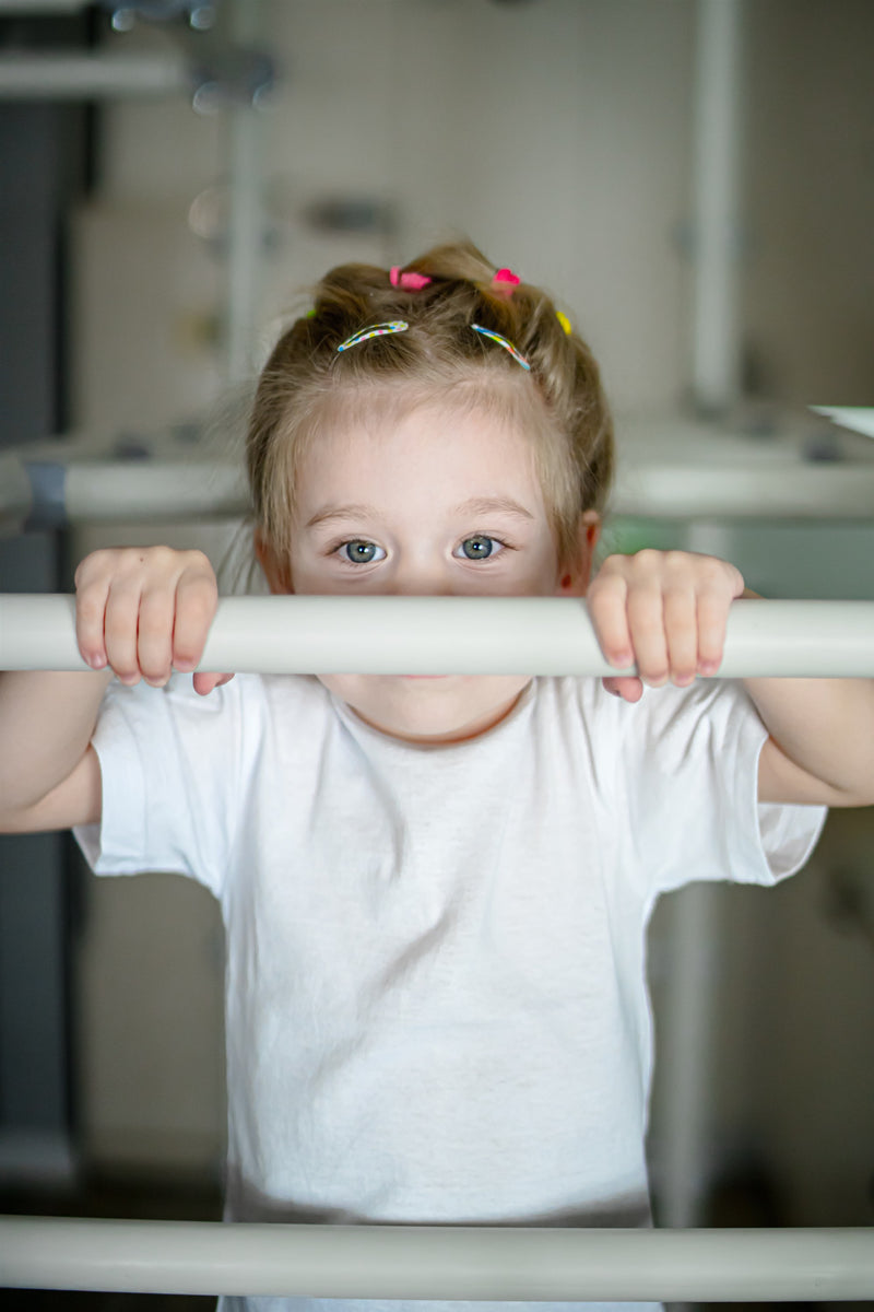 Toddler girl peeking over a rung