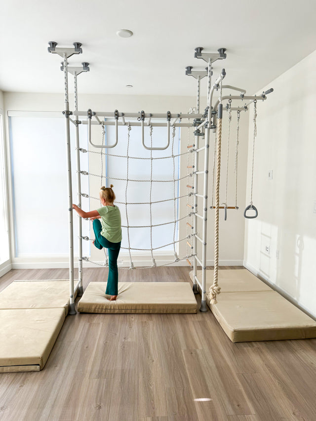 Girl climbing the rope ladder on a Brainrich indoor play gym