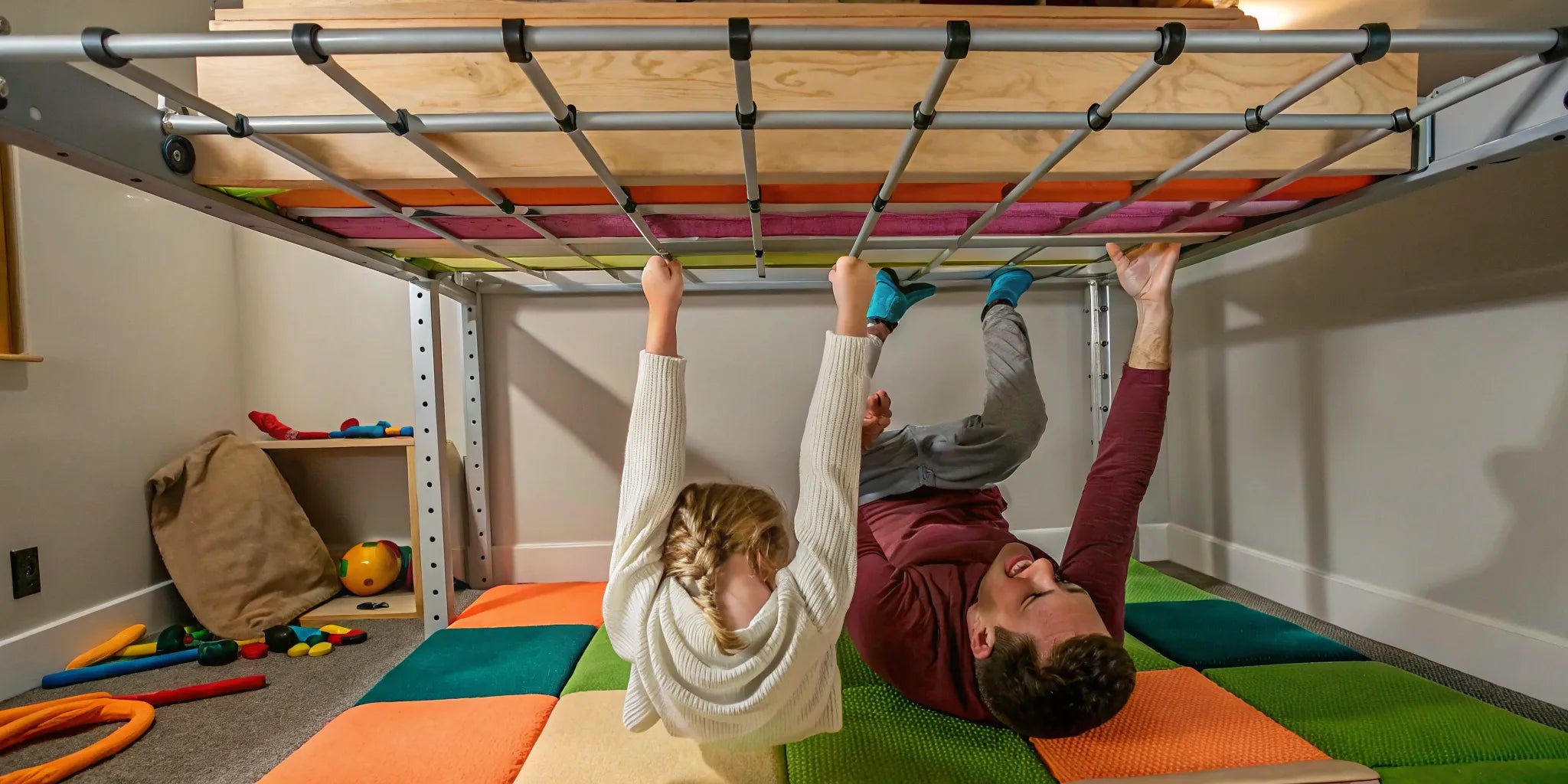 Child safely using ceiling-mounted monkey bars.