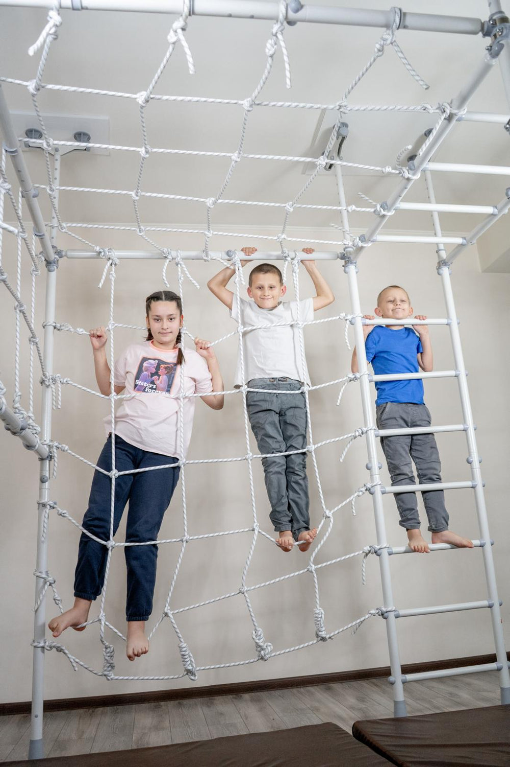 Three kids climbing the net together